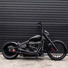 a black motorcycle parked in front of a garage door