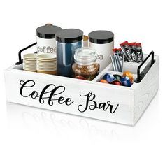 a coffee bar tray with cups, candy bars and candies in it on a white background