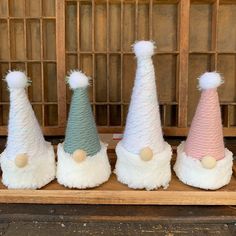 four small hats with pom poms on them