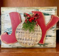 a wooden sign with the word joy painted on it