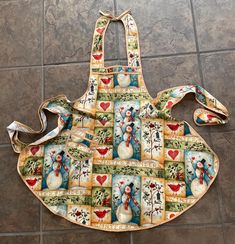 an apron with snowmen on it is sitting on the floor next to a tile floor