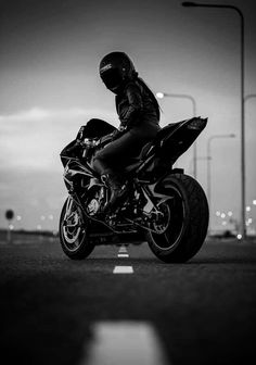 a man riding on the back of a black motorcycle