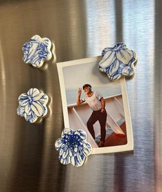 an image of a man standing on a boat with flowers in front of him and three other buttons