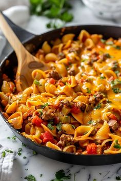 a skillet filled with pasta and meat covered in sauce, cheese and parsley