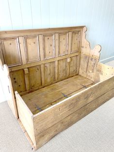 an old wooden bed frame sitting on top of carpeted floor next to a wall