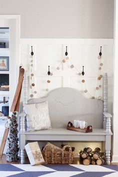 a white bench sitting in the middle of a living room next to a christmas tree