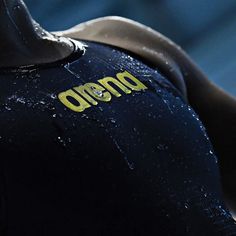 the back of a person's wetsuit with words on it and gold lettering