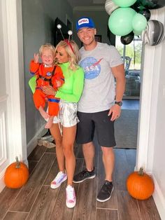 a man and woman are standing in the doorway with two small children on their shoulders