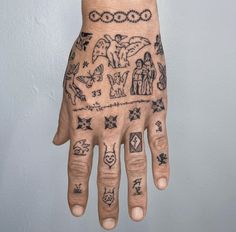 a person's hand with tattoos on it and other symbols drawn on the palm