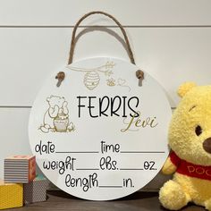 a winnie the pooh sign next to a teddy bear