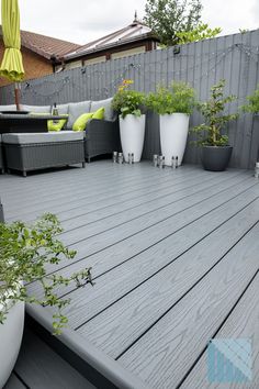 Modern garden design with anthracite grey decking Grey Fence And Decking, Decked Patio Ideas, Grey Pool Decking, Light Grey Fence Garden, Plastic Decking Ideas