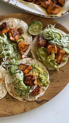 chicken tacos with avocado and cilantro on a wooden platter