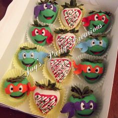 twelve decorated cupcakes in the shape of teenage mutant ninja turtles and strawberries