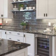 a kitchen with marble counter tops and white cabinets