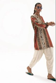 Introducing our stunning and chic two-piece kurta and pants set - a must-have addition to your wardrobe. Made from high-quality fabric, this set is designed for both comfort and style. The kurta features delicate details that add a touch of elegance to your look. The length of the kurta is just right, hitting just above the knees for a modern and sophisticated look.  The pants are designed in a straight leg style, featuring a comfortable and adjustable waistband for a perfect fit. The length is just right to complement the kurta, creating a cohesive and stylish outfit. Whether you're attending a wedding, Eid celebration, or simply want to elevate your everyday look, this set is perfect for any occasion. Pair it with your favorite accessories, shoes, and bag to create a complete look that w Designer Long Sleeve Festive Pant Set, Festive Lawn Suit With Dabka For Navratri, Bollywood Style Long Sleeve Pant Set For Navratri, Long Sleeve Dabka Pant Set For Eid, Traditional Long Sleeve Pant Set, Traditional Long Sleeve Pant Set With Zari Work, Diwali Kurta With Dabka Embroidery, Navratri Self-design Long Sleeve Palazzo Set, Navratri Long Sleeve Palazzo Set With Self Design