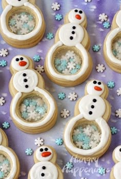 decorated cookies with frosting and snowmen are on a purple tablecloth, surrounded by snowflakes