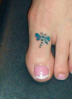 the foot has a dragonfly tattoo on it