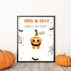 there is a poster on the wall next to two pumpkins and one has a trick or treat