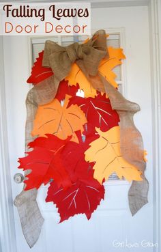 a wreath made out of fall leaves is hanging on the front door with burlocks