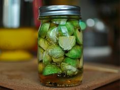 a jar filled with pickles sitting on top of a wooden table