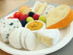 a white plate topped with different types of crocheted items on top of a wooden table