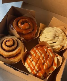 four different types of doughnuts in a box with sauce and pretzels