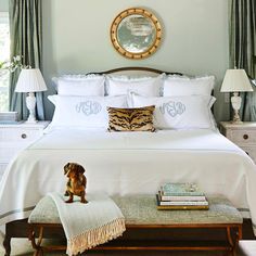 a bed with white sheets and pillows in a bedroom