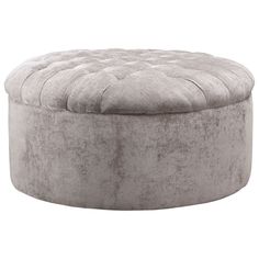 a round ottoman that is made out of grey velvet and has buttons on the top