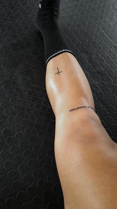 a person with a cross tattoo on their leg