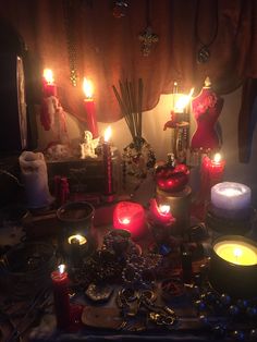 a table topped with lots of different types of candles and other items on top of it