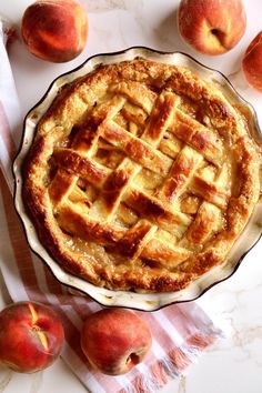 a pie sitting on top of a table next to some peaches