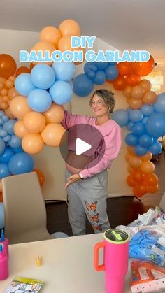 a woman standing in front of a balloon arch