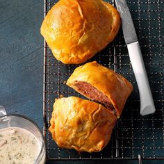 two pastries sitting on top of a cooling rack next to a bowl of soup