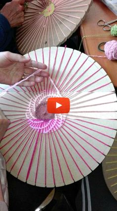 the woman is working on crafts with her handmade parasols and knitting needles