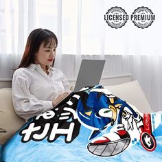 a woman sitting on a couch with a laptop computer in front of her and an image of sonic the hedgehog