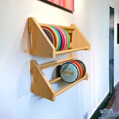 two wooden shelves holding plates and bowls on the wall