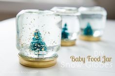 snow globes with tiny trees in them sitting on a table