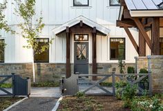 a white house with a gray door and gate