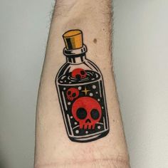 a man's arm with a skull in a bottle tattoo on it