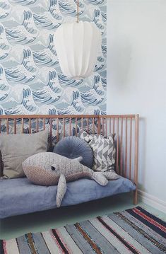 a blue and white wallpaper in a child's room with a wooden crib