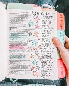 someone is holding up a bible with stars on it and the words you are written in them