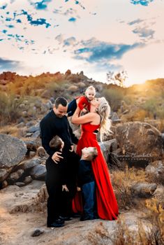 a man and woman hug each other while standing on rocks in the middle of a desert