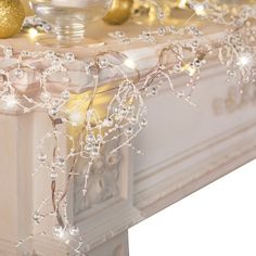 a white mantle decorated with gold ornaments and lights