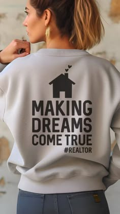 a woman wearing a sweatshirt that says making dreams come true realtor