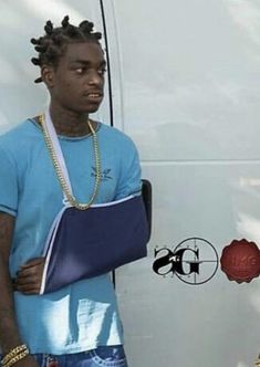 a man standing next to a white van wearing a blue t - shirt and holding a binder