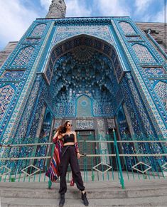 a woman standing in front of a blue building