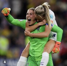 two female soccer players are hugging each other