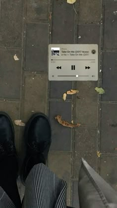 a person standing on the sidewalk with their feet propped up in front of an arrow sign