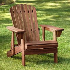 a wooden chair sitting on top of a lush green field