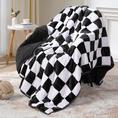 a black and white checkered blanket sitting on top of a chair next to a teddy bear